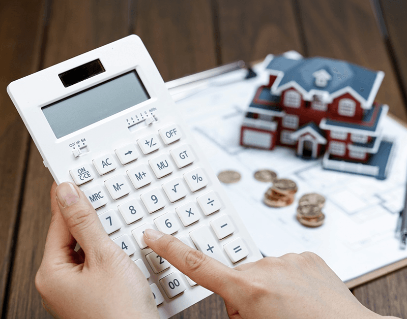 Person using a calculator to calculate their home purchase